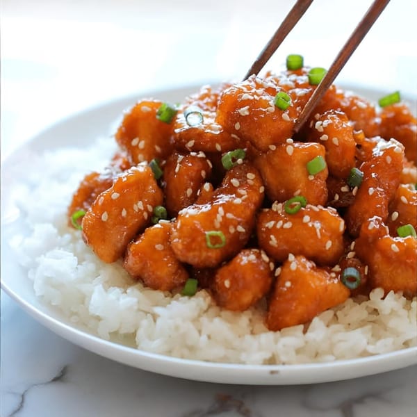 Ying Li Restaurant's orange chicken with sesame seeds and green onions, served over white rice.